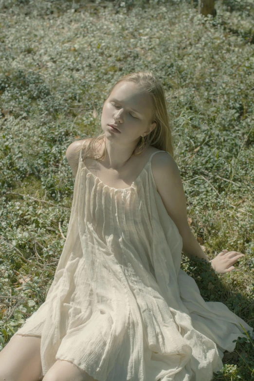 a woman in a white dress sitting in the grass, an album cover, inspired by Nell Dorr, unsplash, renaissance, elle fanning), serge marshennikov, young teen, grainy movie still