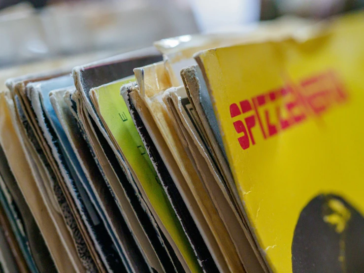 a stack of records sitting on top of a table, an album cover, unsplash, ((yellow magic orchestra)), splento, zoomed in, stephen silver