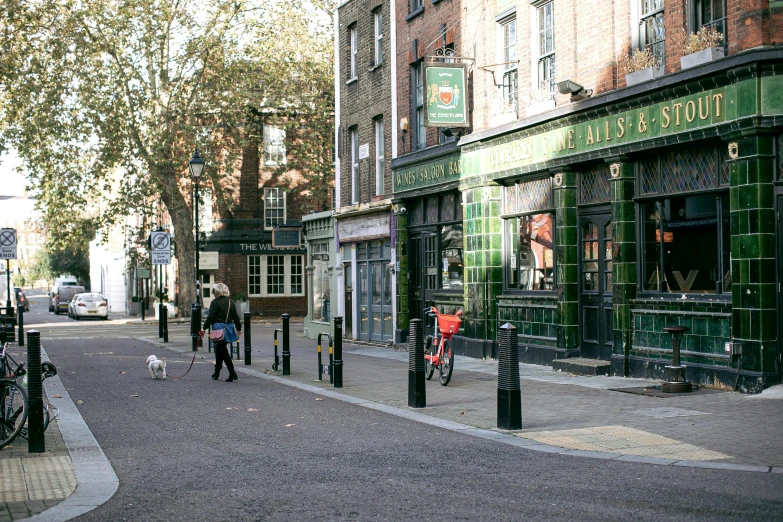 a group of people walking down a street, pub, black and green scheme, empty streets, ivy's