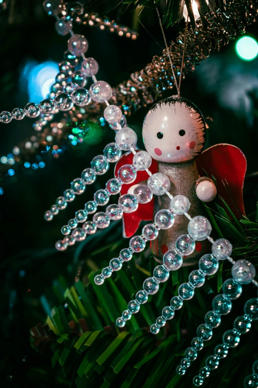 a close up of a christmas ornament on a tree, a portrait, by Julia Pishtar, pexels contest winner, process art, beads, angel themed, ai robot tendril remnants, emitting light ornaments