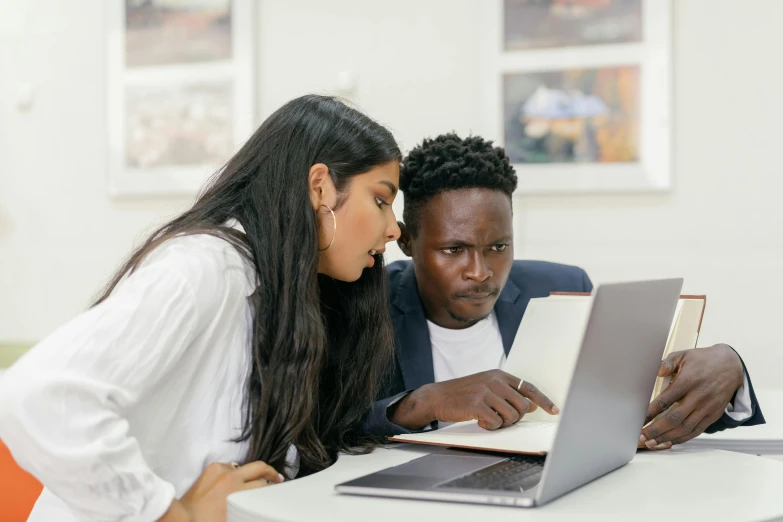 a man and a woman looking at a laptop, trending on pexels, teaching, ( ( dark skin ) ), a wide shot, performing