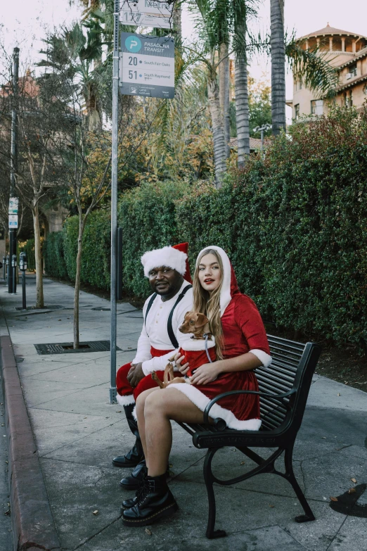 a couple of people that are sitting on a bench, by Ryan Pancoast, happening, santa clause, los angelos, violet myers, wearing festive clothing