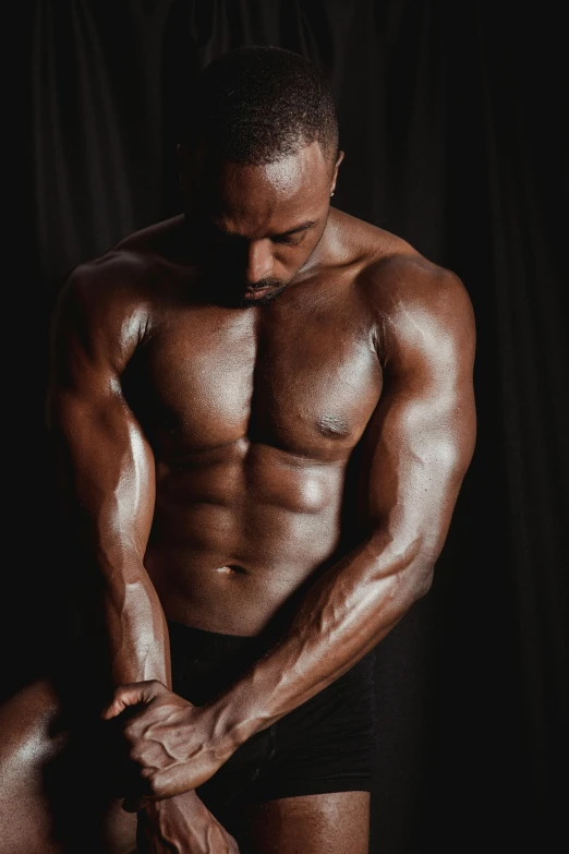 a man flexing his muscles in front of a black background, inspired by Terrell James, oiled skin, profile image, physical : tinyest midriff ever, instagram photo