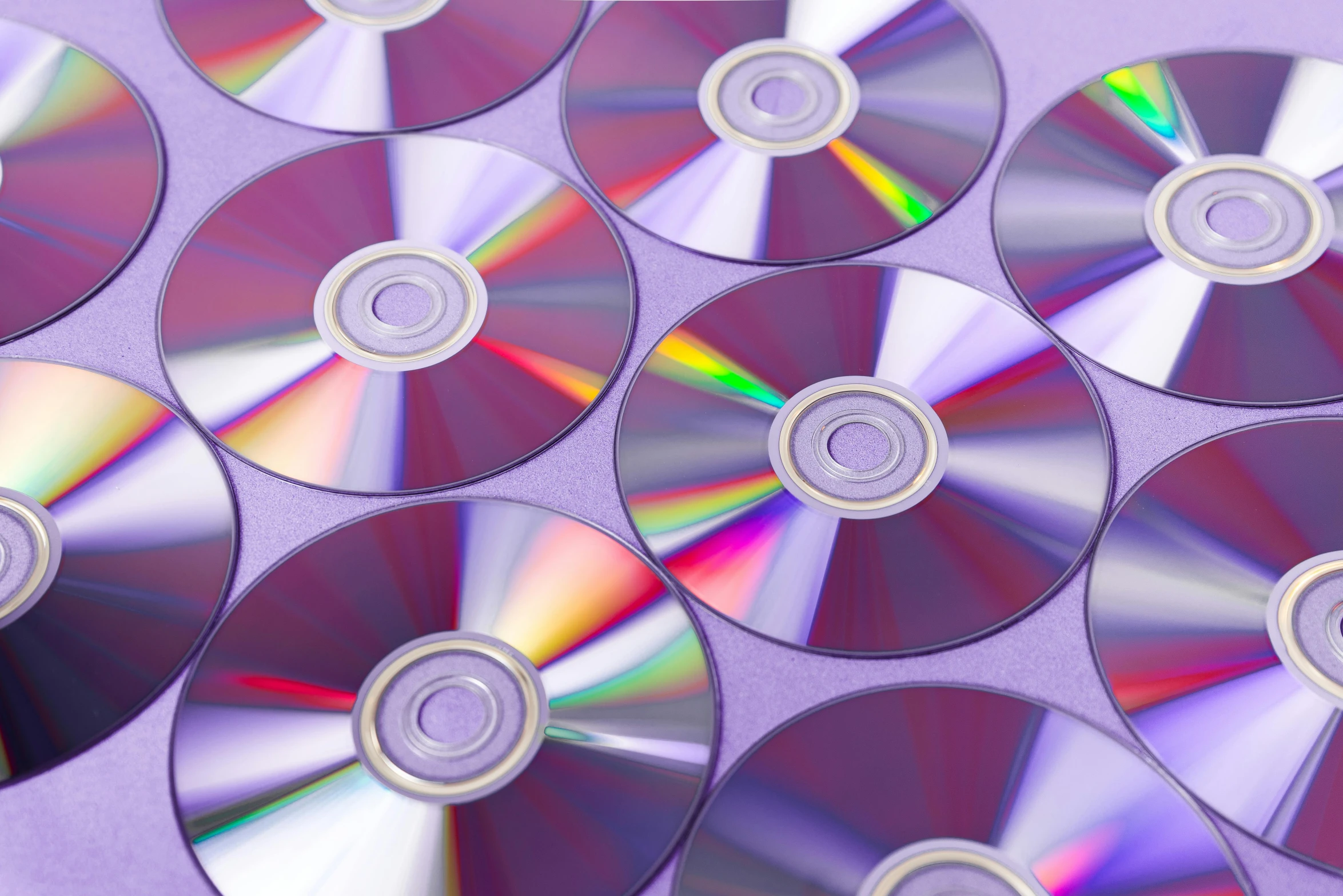 a bunch of cds sitting on top of a table, pexels, holography, purple, dvd cover, look at the details, plain background