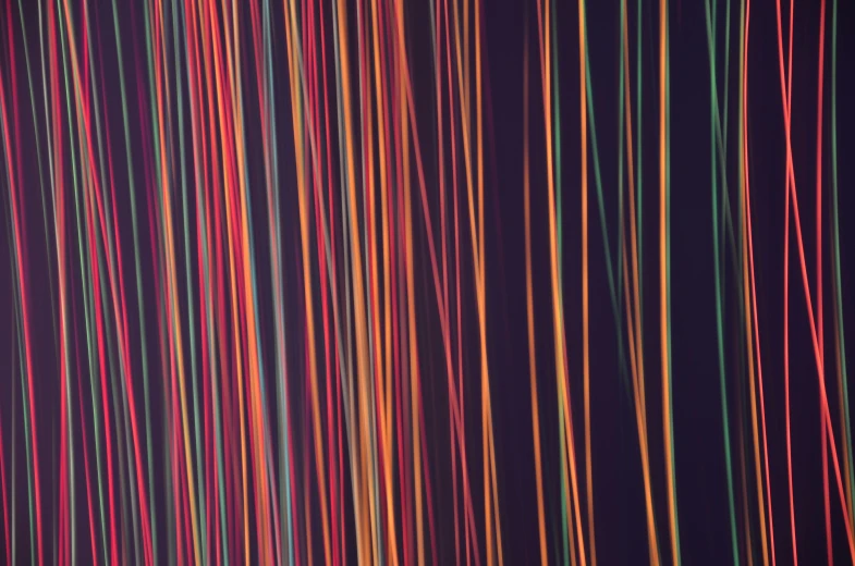 a long line of multicolored lines on a black background, a microscopic photo, pexels, generative art, red orange lighting, thick wires looping, random background scene, long exposure