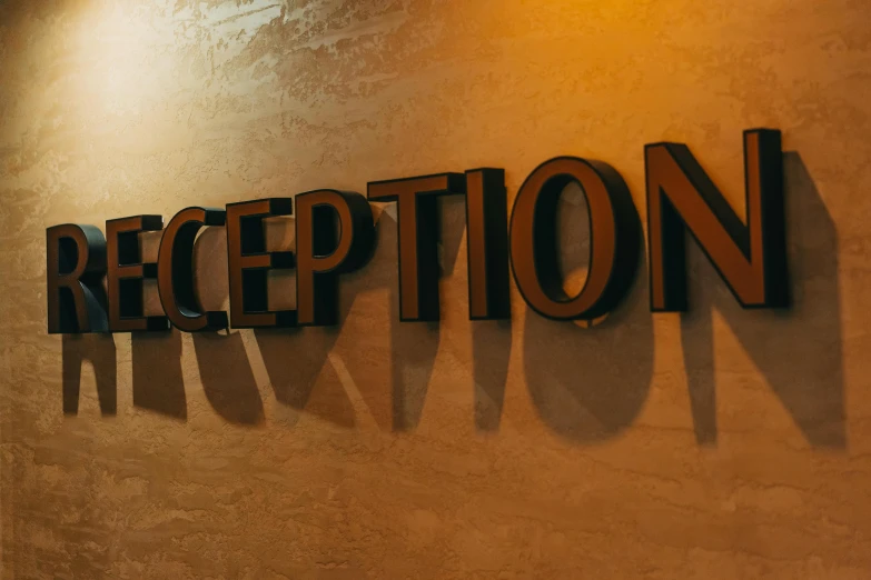 a sign that says reception on a wall, unsplash, avatar image, brown, inception, exceptional lighting