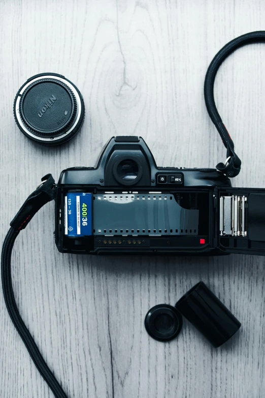 a camera sitting on top of a wooden table, by Matthias Stom, unsplash, fujifilm superia, flatlay, rear-shot, ecommerce photograph