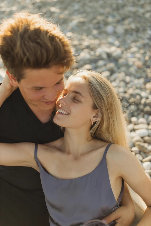 a man and woman sitting next to each other on a beach, pexels contest winner, renaissance, a girl with blonde hair, flirting smiling, soft backlighting, grey