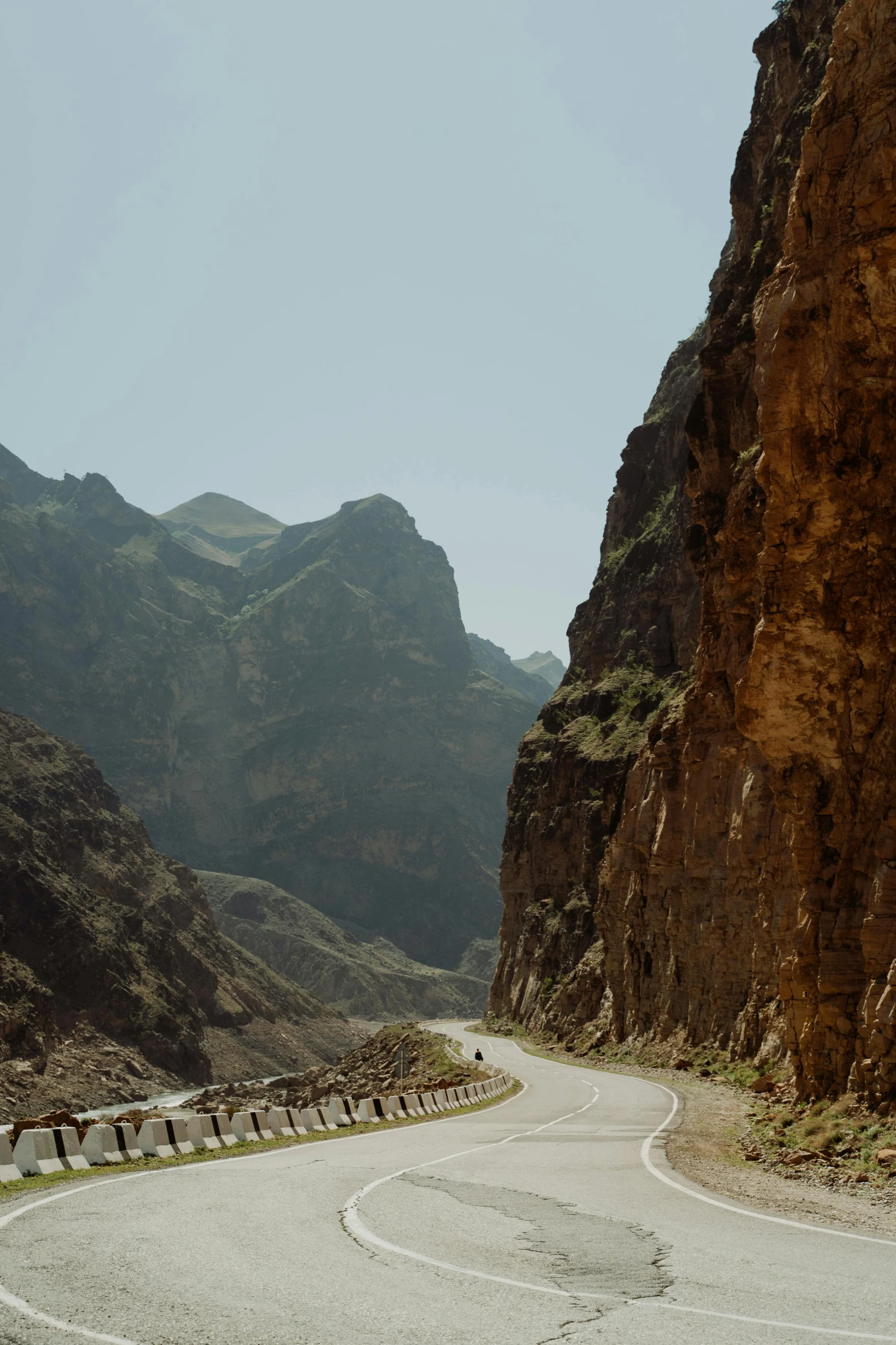 a man riding a motorcycle down a curvy road, les nabis, kurdistan, brown canyon background, banner, gumroad