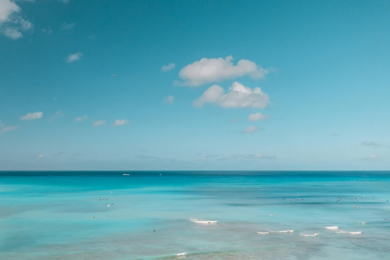 a large body of water next to a beach, pexels contest winner, carribean turquoise water, plain uniform sky, in style of joel meyerowitz, blue atmosphere