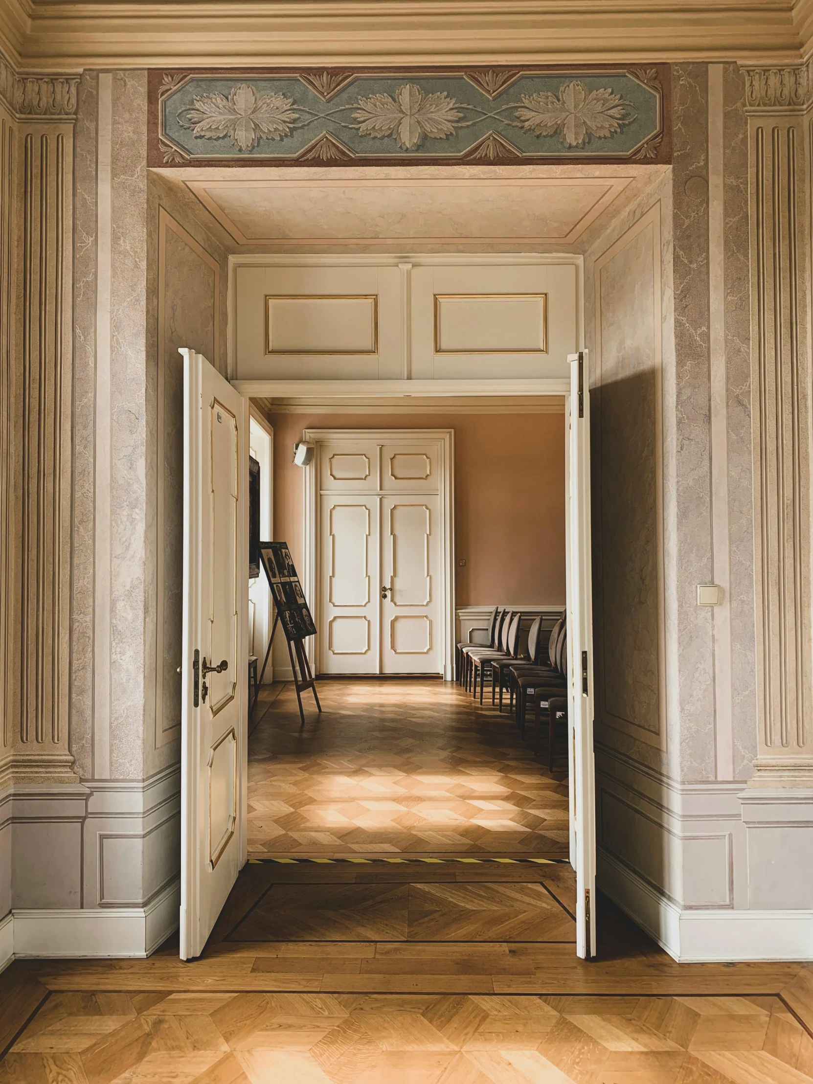 a room with a door and a chair in it, inspired by Wilhelm Hammershøi, pexels contest winner, neoclassicism, high ceiling, mansion, looking left, waiting room