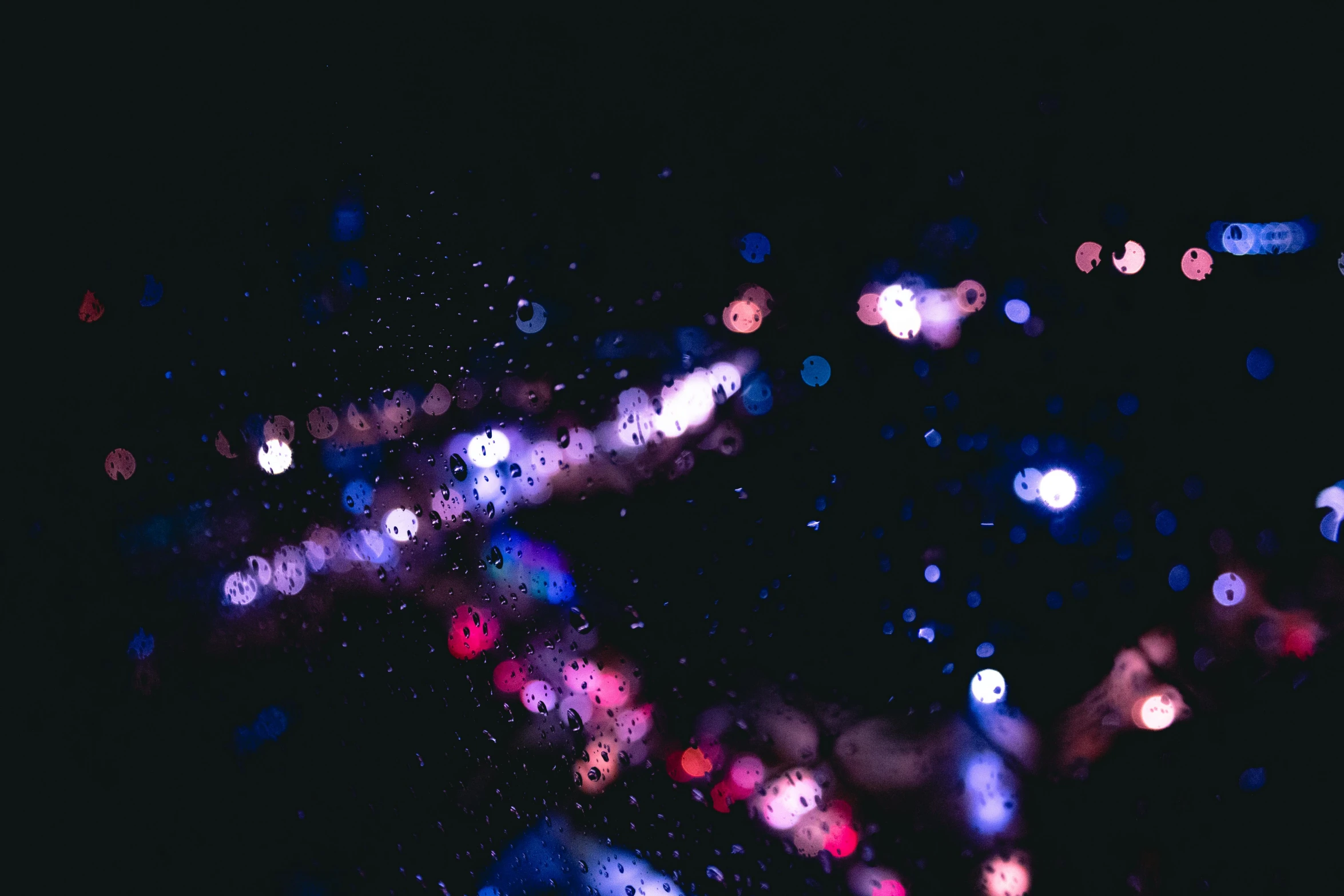 a blurry photo of a city at night, a microscopic photo, by Niko Henrichon, unsplash, light and space, raindrops, red and blue black light, purple sparkles, brandon woelfel