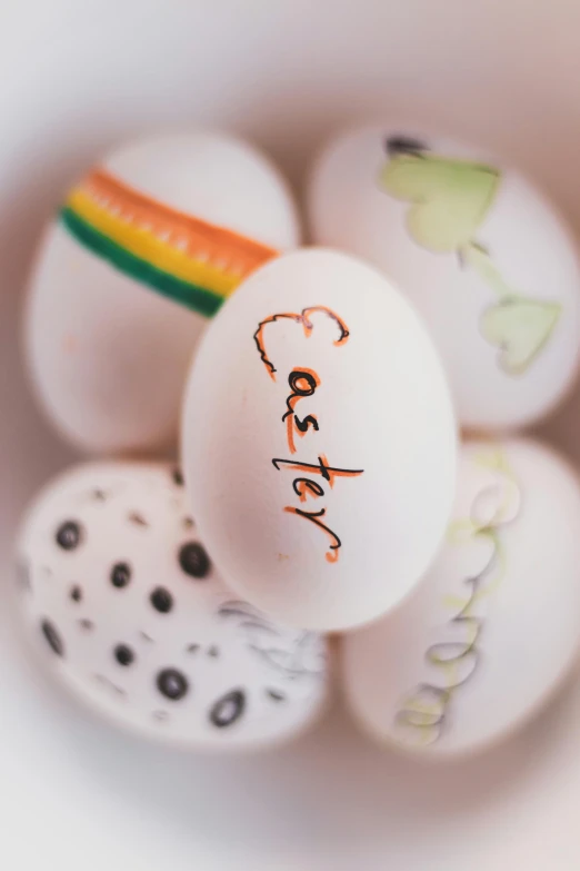 a bunch of white eggs with drawings on them, trending on pexels, rainbow, detail shot, multiple stories, brown