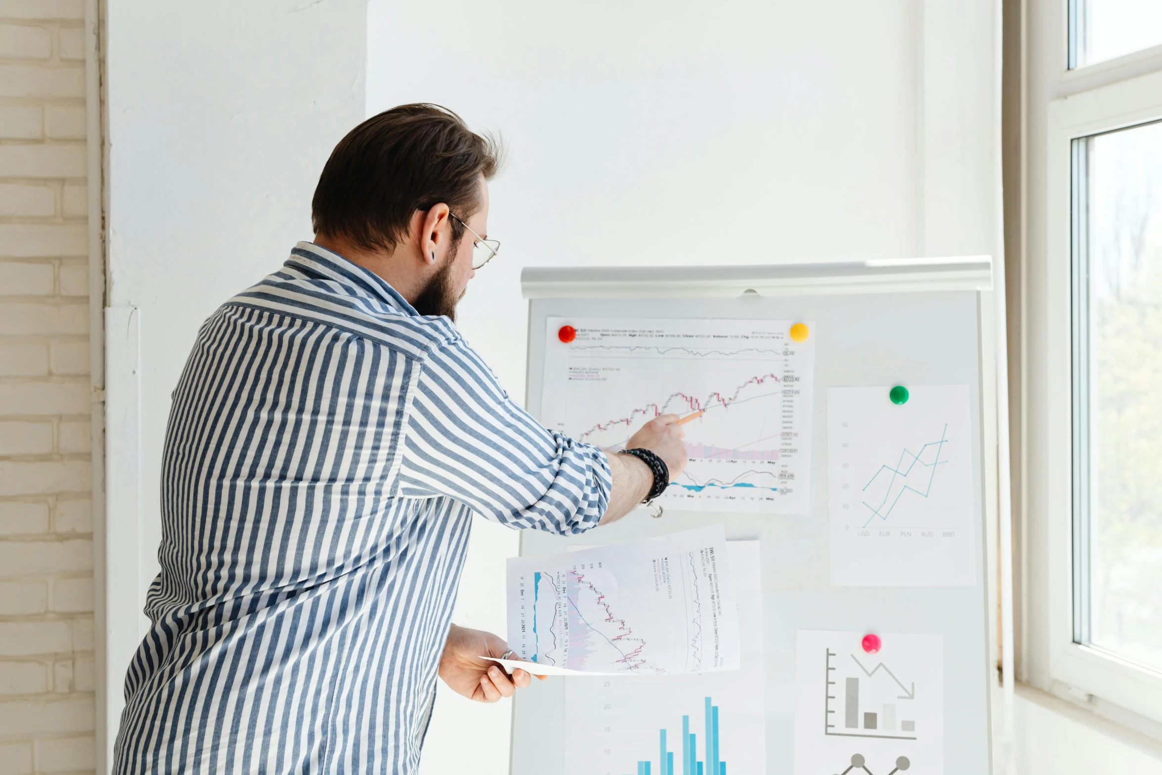 a man standing in front of a white board with graphs on it, trending on unsplash, 15081959 21121991 01012000 4k, writing on a clipboard, catalog photo, stacked image