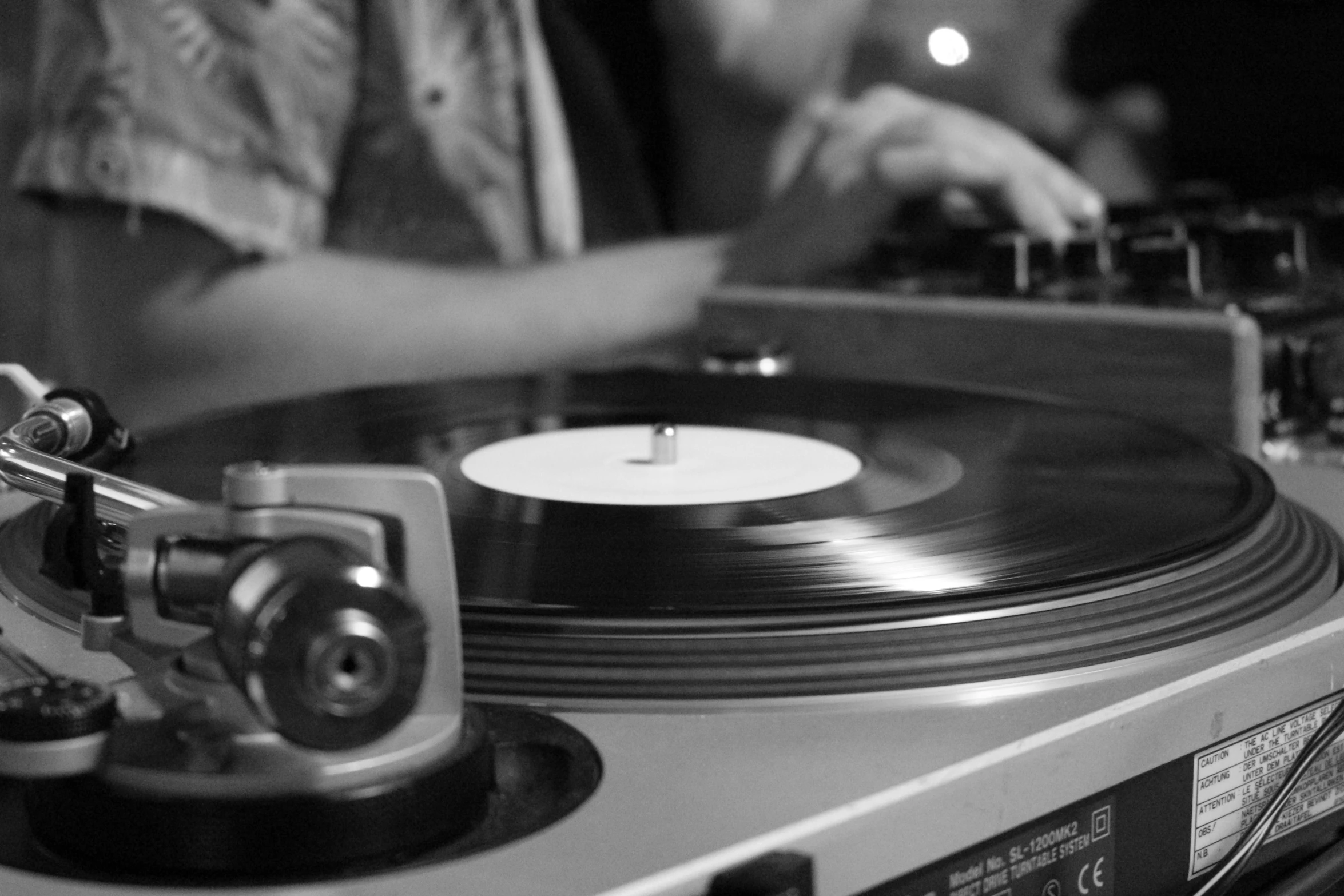 a close up of a person playing a record on a turntable, by Felix-Kelly, black & white photo, dj, uploaded, summer night