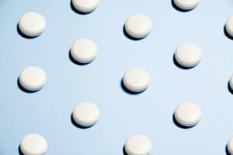 a lot of white pills on a blue surface, an illustration of, by Évariste Vital Luminais, trending on pexels, sleek round shapes, white panels, dezeen, white freckles