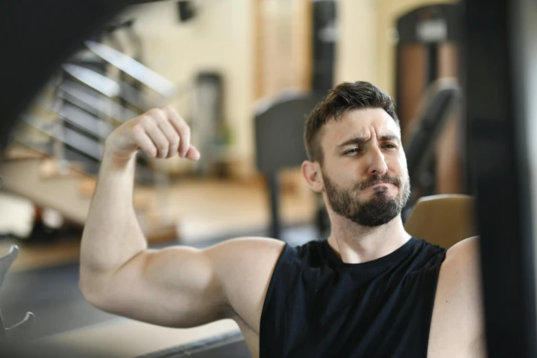 a man flexing his muscles in a gym, a portrait, pexels contest winner, square jaw-line, avatar image, annoyed, 2 9 years old