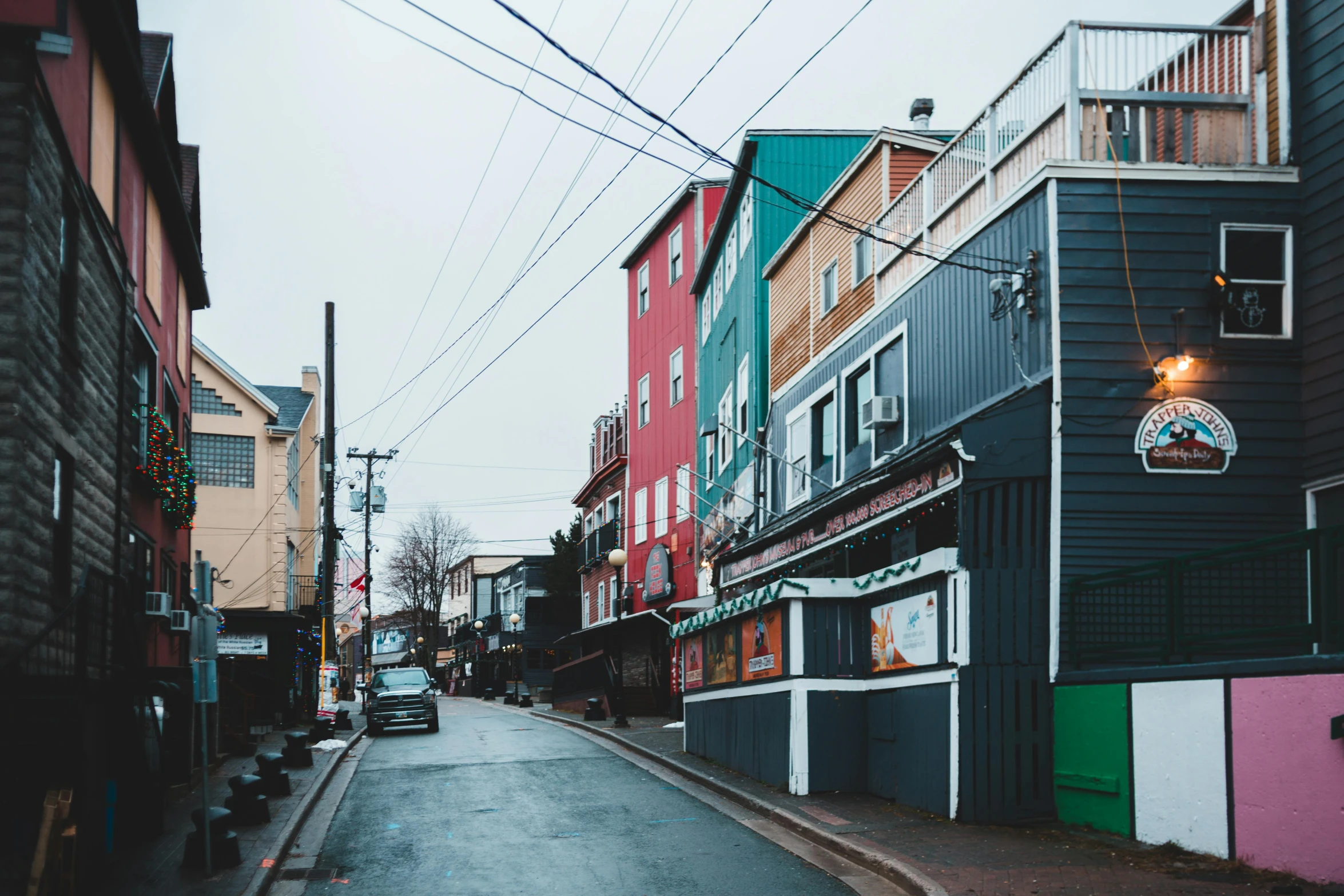 a city street filled with lots of colorful buildings, a photo, by Carey Morris, pexels contest winner, alaska, grey, coastal, crisp lines