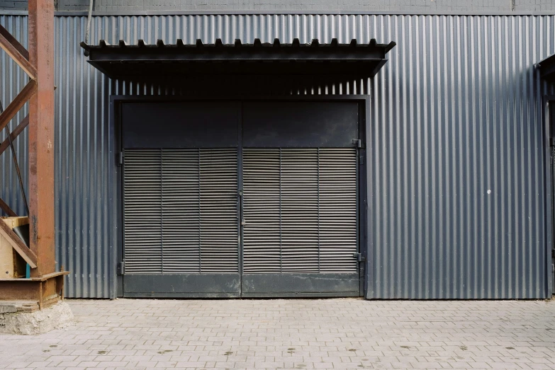 a red fire hydrant sitting in front of a building, a digital rendering, unsplash, postminimalism, iron gate door texture, black vertical slatted timber, john pawson, inside a warehouse