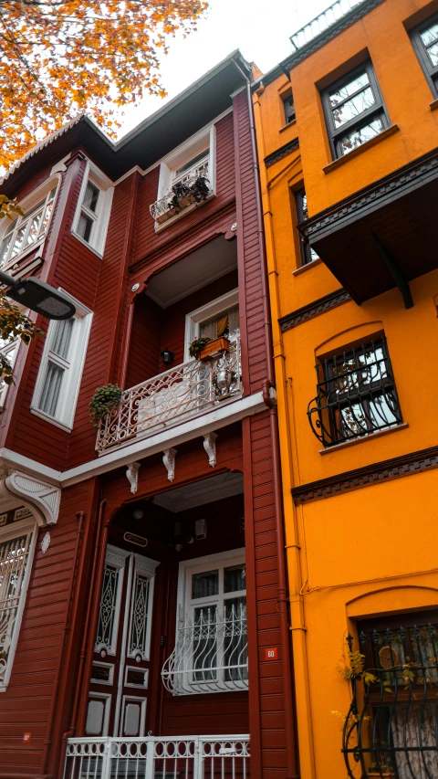 a couple of buildings that are next to each other, by irakli nadar, pexels contest winner, art nouveau, yellows and reddish black, istanbul, standing outside a house, three colors