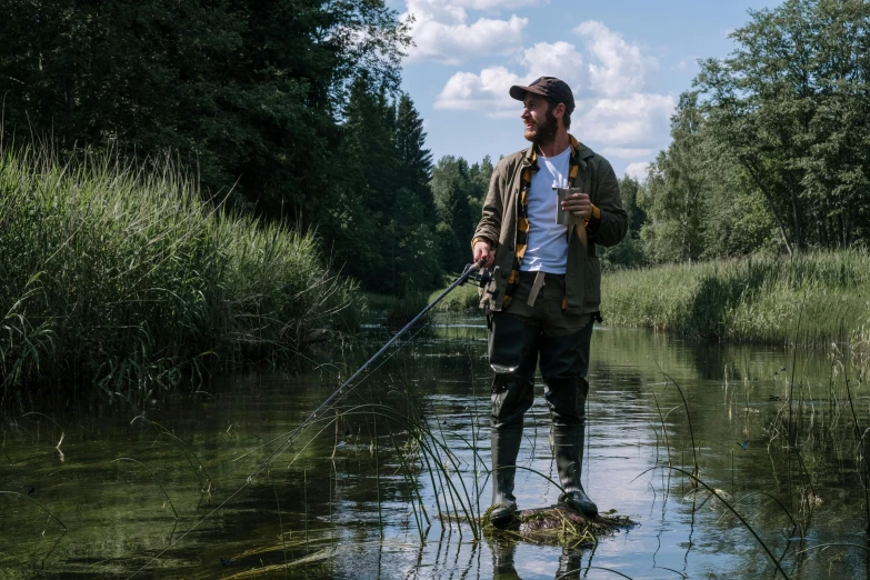 a man standing in a river holding a fishing rod, tarmo juhola, influencer, ede laszlo, high quality image