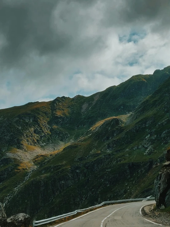 a motorcycle parked on the side of a mountain road, a detailed matte painting, by Emma Andijewska, pexels contest winner, renaissance, 4 k cinematic panoramic view, alduin, looking threatening, banner