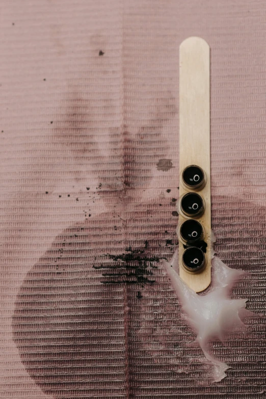 a toothbrush sitting on top of a wooden stick, an album cover, inspired by Lucio Fontana, unsplash, conceptual art, abstract smokey roses, buttons, lacquer on canvas, burned