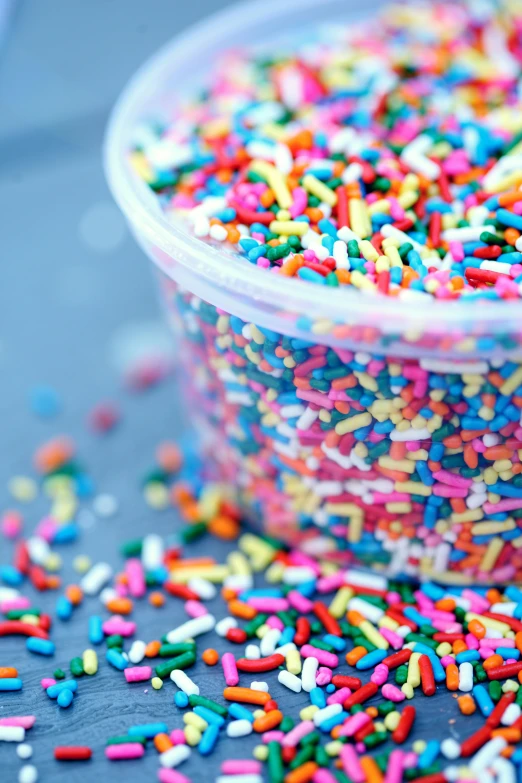 a plastic container filled with sprinkles on top of a table, by Jason Felix, pexels, kek, multilayer, wide, multicolor