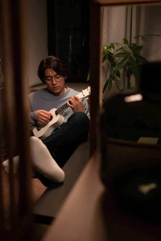 a woman sitting on the floor playing a guitar, inspired by Hideyuki Kikuchi, reddit, cinematic shot ar 9:16 -n 6 -g, a handsome, low quality photo, ukulele