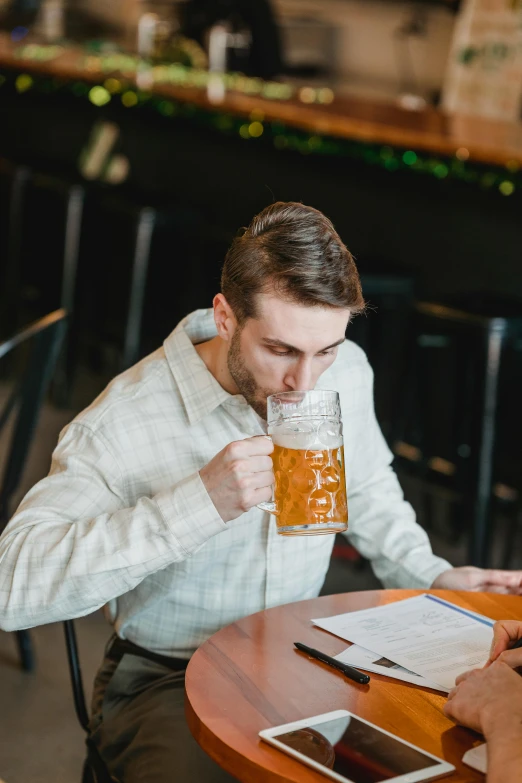 two men sitting at a table drinking beer, pexels, beer mug in hand, reading, gif, casually dressed