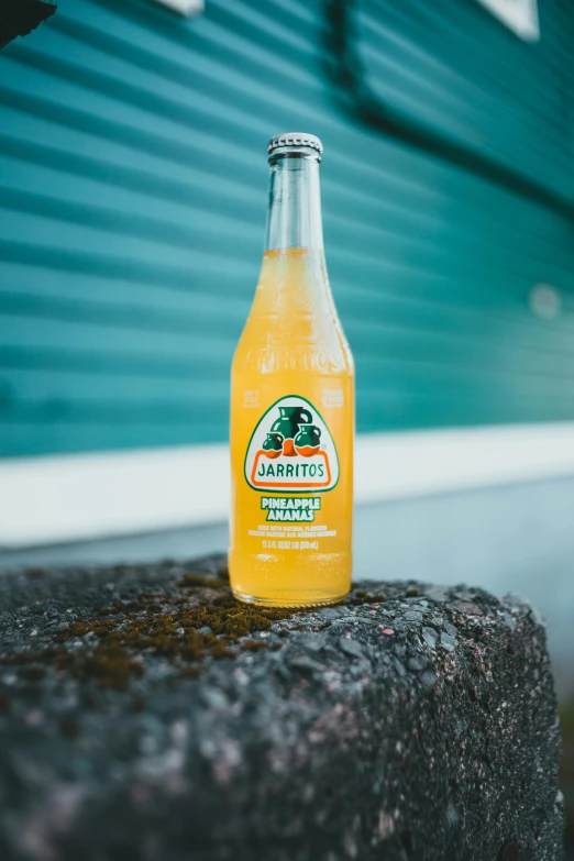 a bottle of orange soda sitting on top of a rock, by James Jarvaise, unlimited juice, mint, pineapple, thumbnail