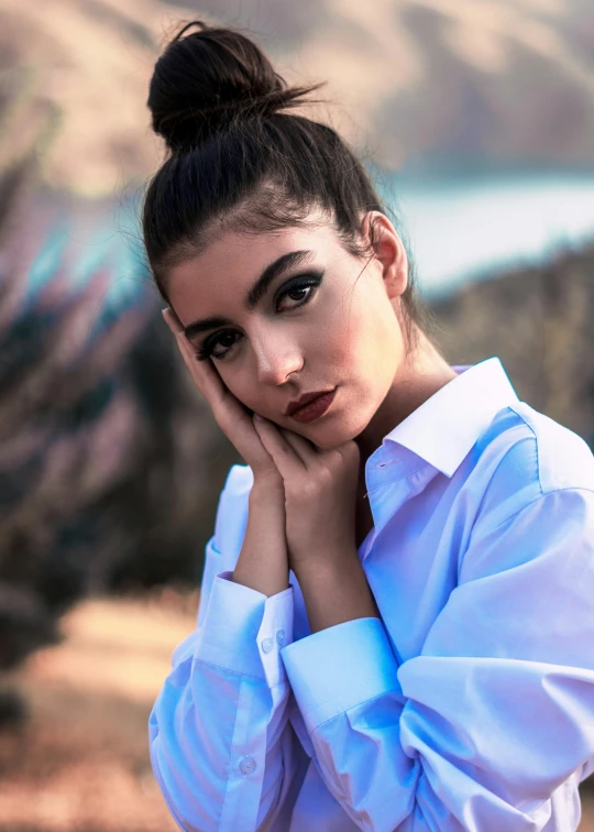 a woman in a blue shirt posing for a picture, an album cover, trending on pexels, beautiful iranian woman, white dress shirt, tense look, handsome girl