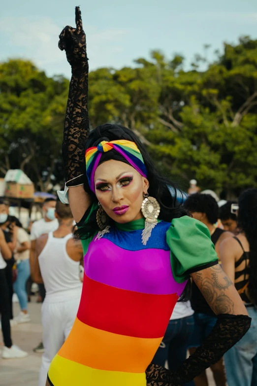 a woman in a rainbow dress posing for a picture, an album cover, trending on pexels, brazil carnival, androgynous, square, chile