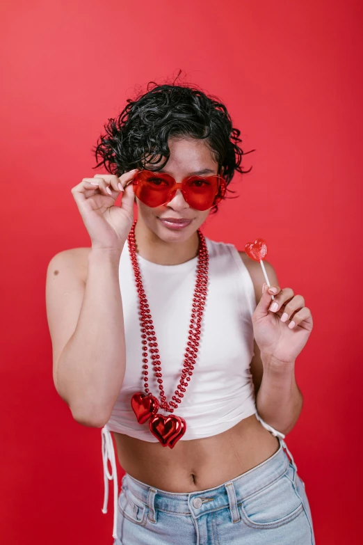 a woman wearing a heart shaped necklace holding a cigarette, made of lollypops, red sunglasses, non binary model, from a huge red glass bong