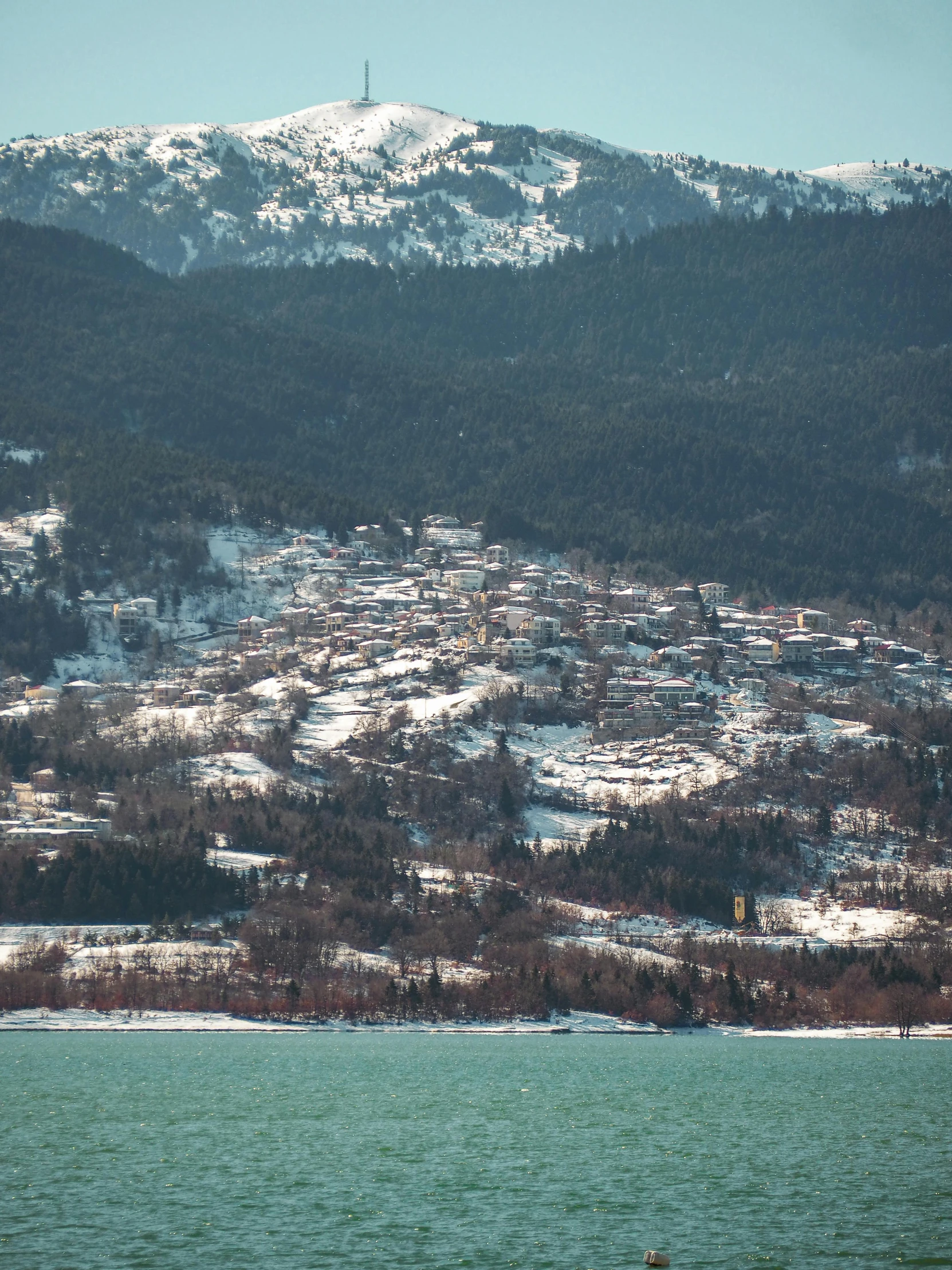 a large body of water with a mountain in the background, during snowfall, view of villages, winter photograph, gigapixel photo