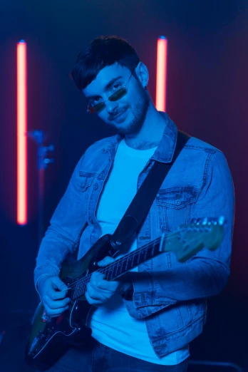 a man that is playing a guitar in a room, blue and red lights, charli bowater, slightly smiling, ( ( stage lights ) )