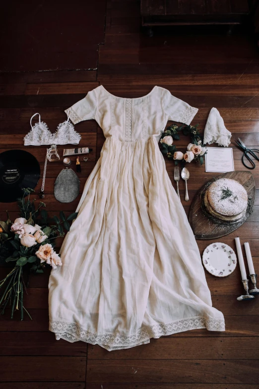 a white dress sitting on top of a wooden floor, a still life, by Jessie Algie, unsplash contest winner, renaissance, flatlay, wearing a wedding dress, peasant dress, ✨🕌🌙