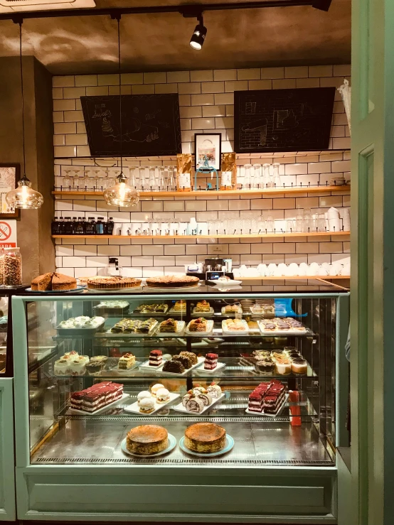 a bakery filled with lots of cakes and pastries, a photo, by Emma Andijewska, art nouveau, view from the side, counter, thumbnail