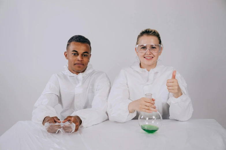 a couple of people that are sitting at a table, lab coat, experimental techniques, giving the thumbs up, high-quality photo