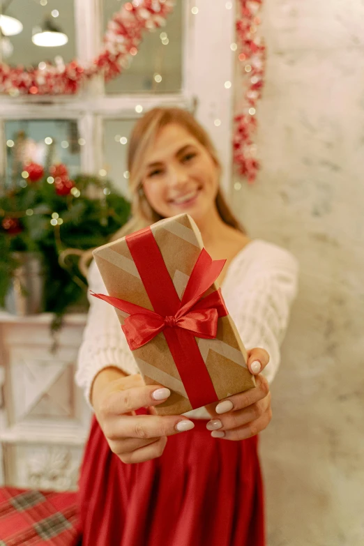 a woman holding a present in front of a christmas tree, pexels contest winner, wide ribbons, avatar image, detail shot, 3/4 front view