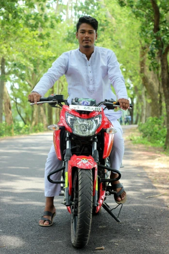 a man riding on the back of a red motorcycle, pexels contest winner, assamese aesthetic, full body frontal view, avatar image, islamic