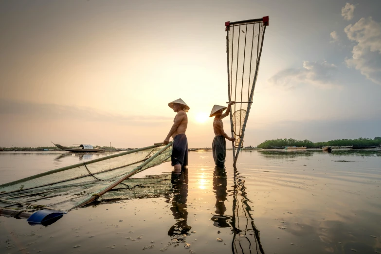 a couple of people standing on top of a body of water, by Jan Tengnagel, pexels contest winner, flooded fishing village, asian sun, slide show, fisherman's hat
