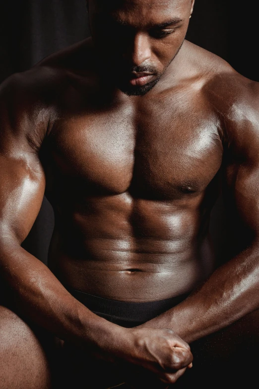 a man that is sitting down with his hands on his knees, an album cover, by Cosmo Alexander, pexels contest winner, renaissance, ifbb fitness body, man is with black skin, physical : tinyest midriff ever, upper body close up