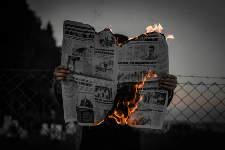 a man holding a burning newspaper in front of his face, an album cover, by Adam Marczyński, pexels contest winner, avatar image, demolition, group photo, profile picture 1024px