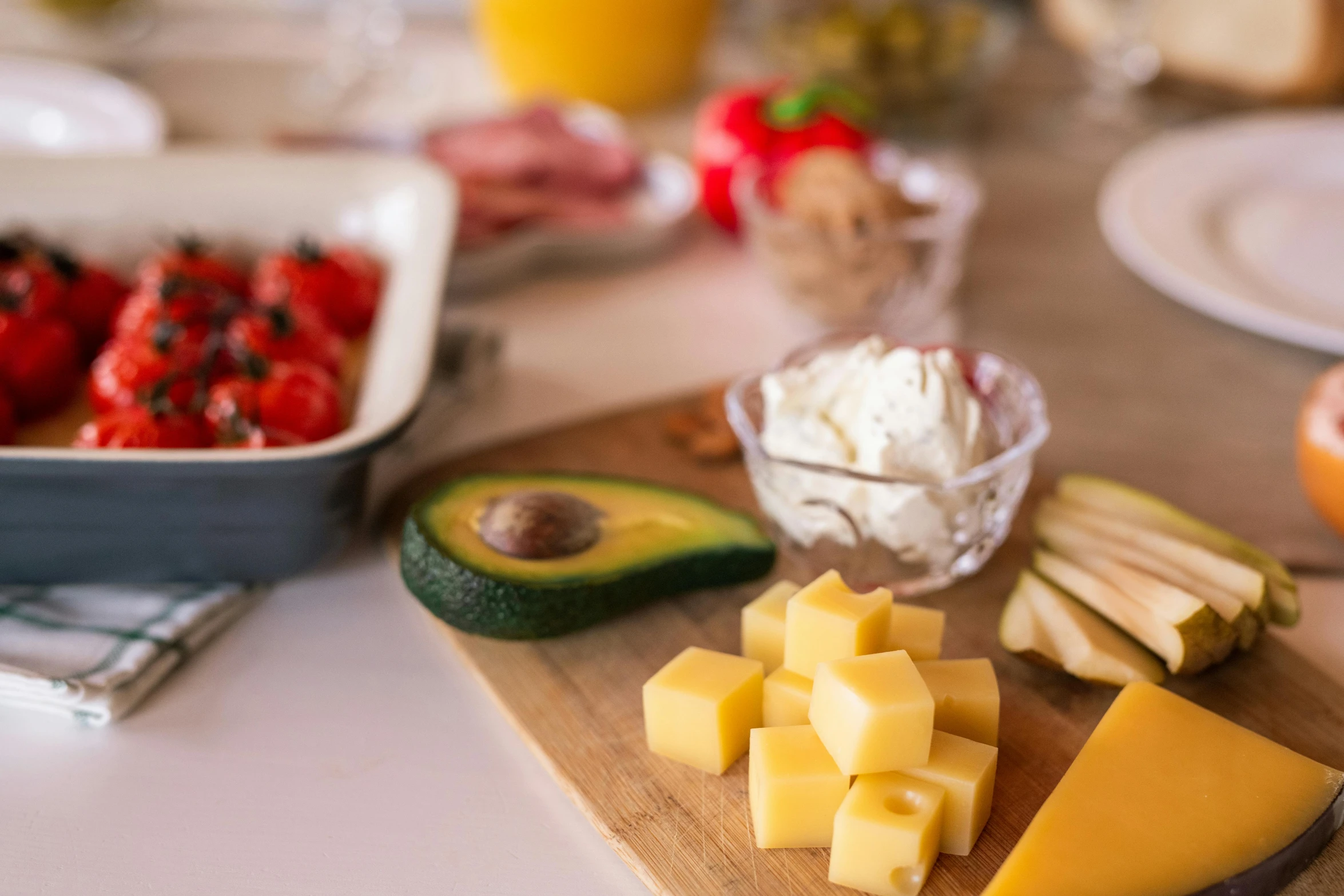 a wooden cutting board topped with cheese and fruit, by Daniel Lieske, pexels, happening, breakfast buffet, avocado and cheddar, detailed product image, glass tableware