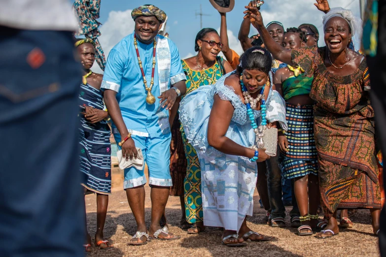 a group of people standing around each other, by Ingrida Kadaka, pexels contest winner, happening, ornately dressed, godwin akpan, triumphant, families playing