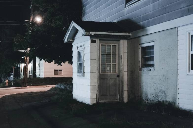 a small white building sitting on the side of a road, an album cover, inspired by Gregory Crewdson, unsplash, dimly lit interior room, secret entrance, neighborhood, profile image