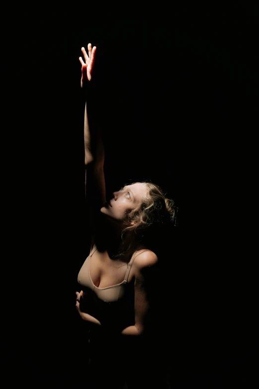 a woman reaching up to catch a frisbee, inspired by Elizabeth Polunin, in a dark studio room, praying, sydney sweeney, holding fire and electricity