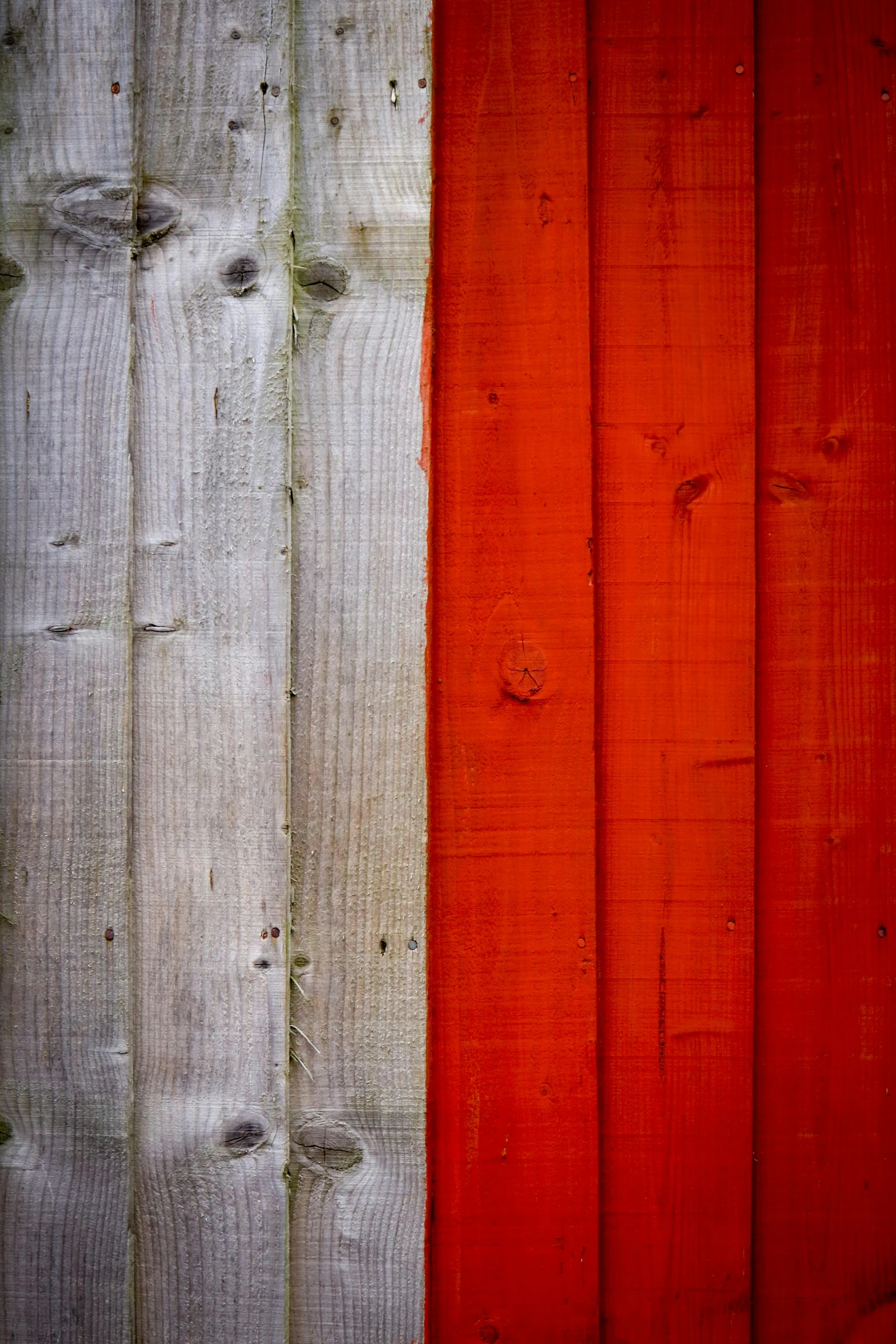 a close up of a wooden fence with red and white paint, an album cover, by Jacek Sempoliński, unsplash, flags, grey orange, poland, made of wood