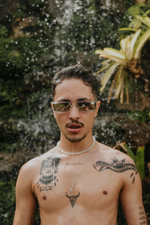 a shirtless man standing in front of a waterfall, an album cover, inspired by Randy Vargas, trending on pexels, he wears an eyepatch, post malone, androgynous person, headshot photo